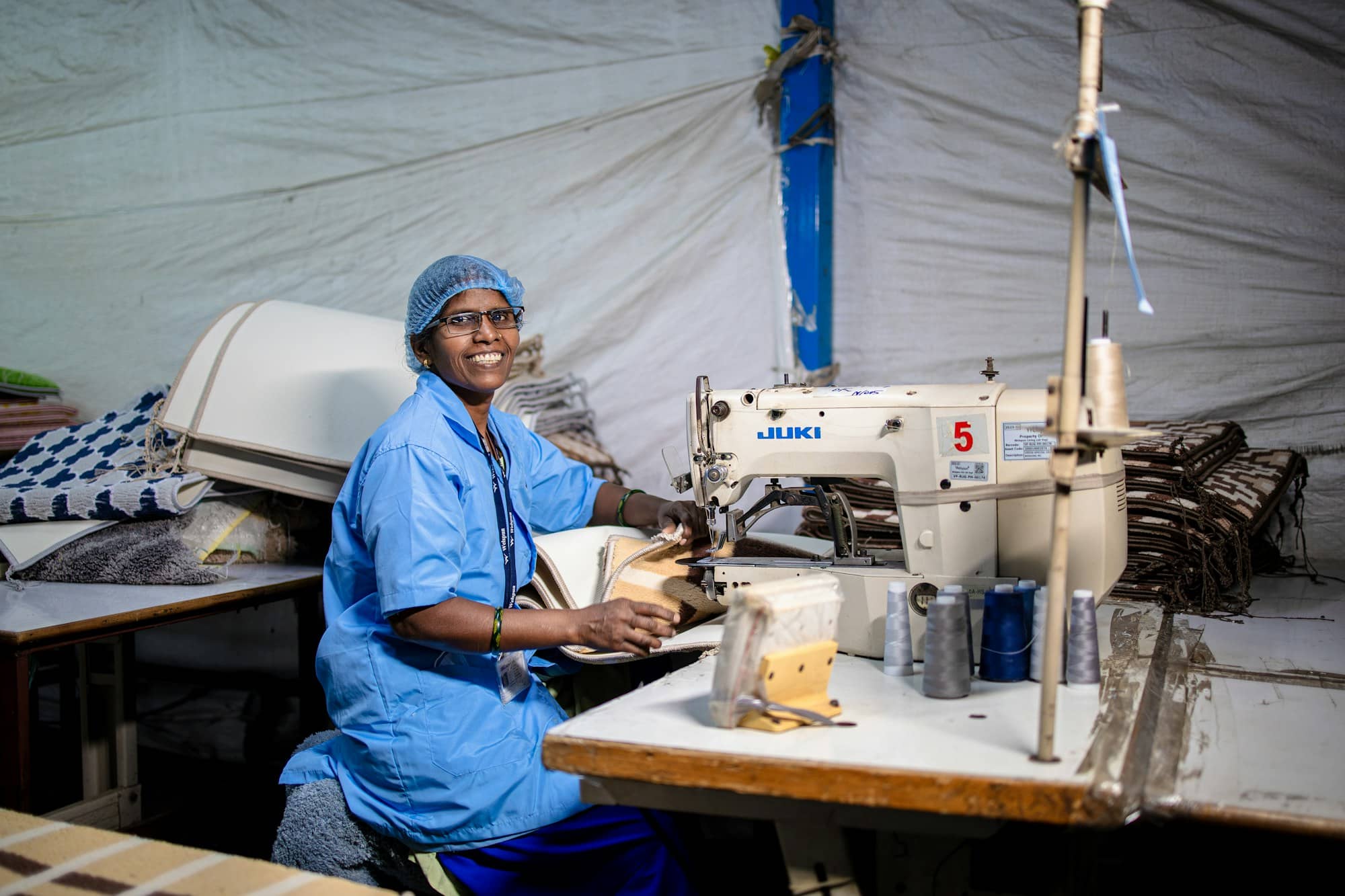 Une ouvrière souriante à son poste de confection