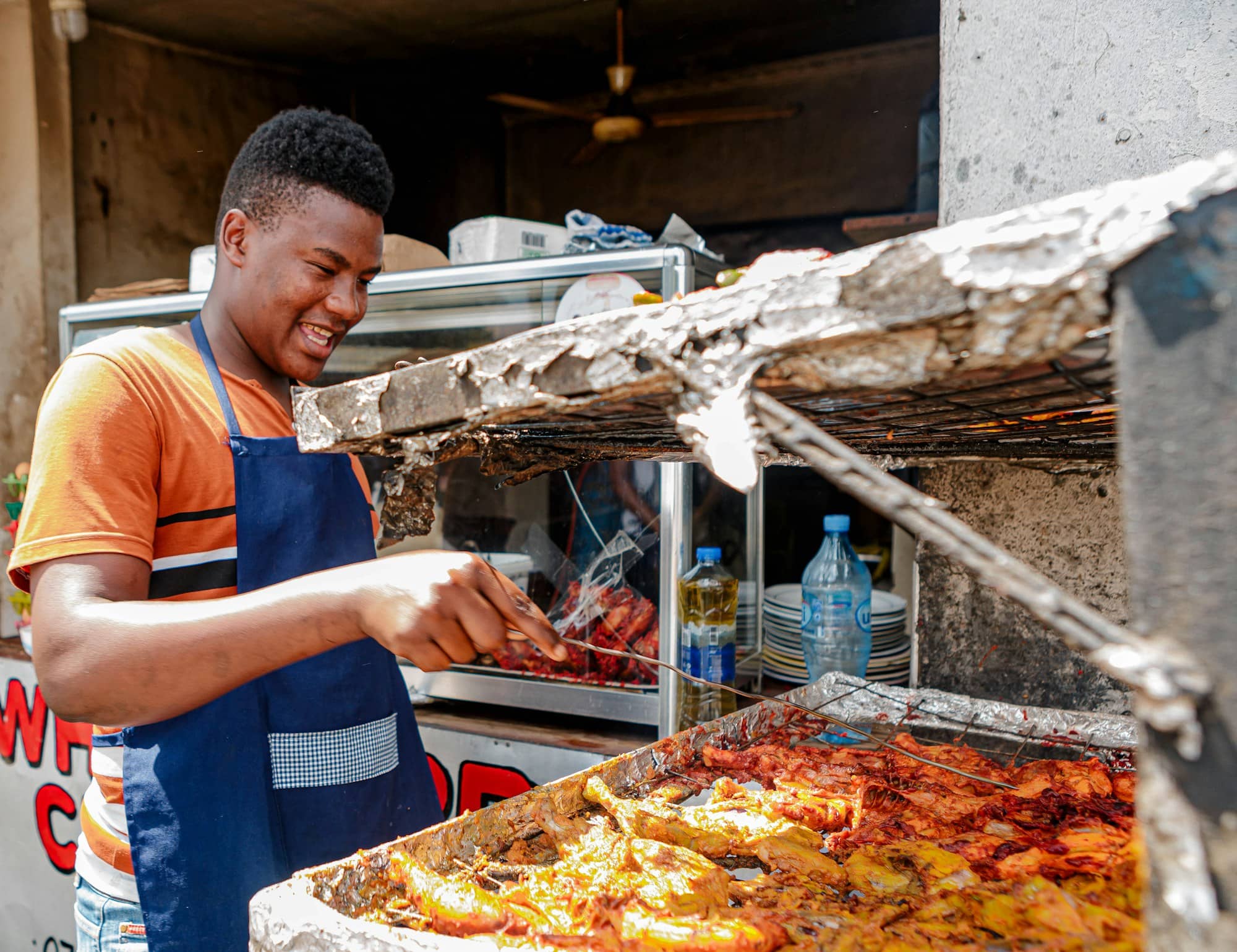 Un jeune restaurateur prépare des grillades à son étal