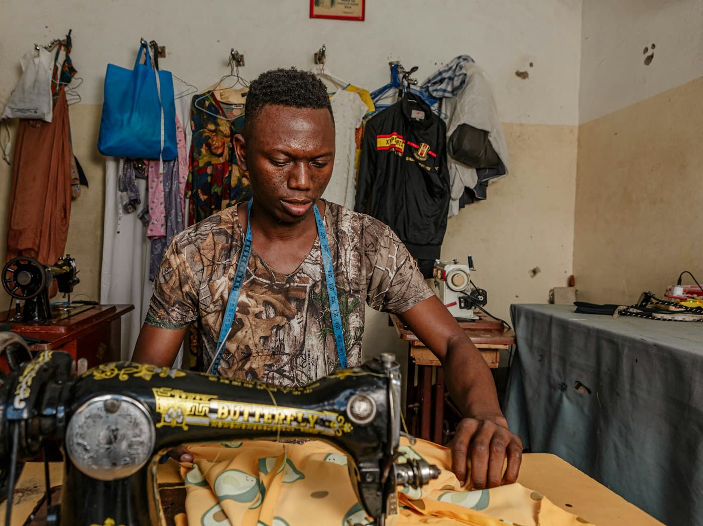Un jeune tailleur à sa machine à coudre